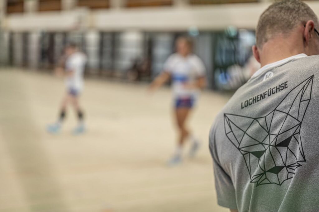 Trainer steht fokussiert am Torpfosten